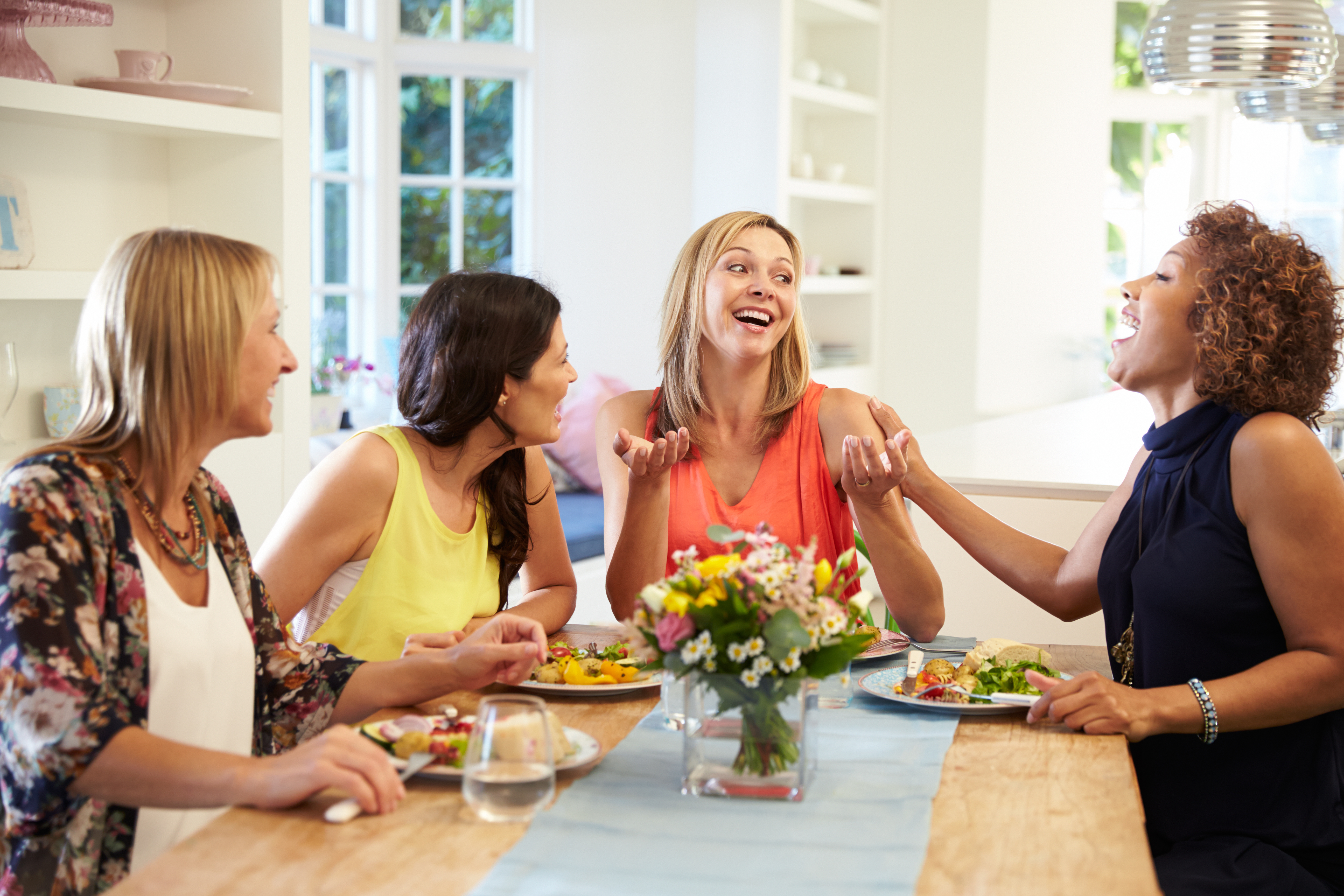 Mature Female Friends Sitting Around Table At Dinner Party Abounding Solutions