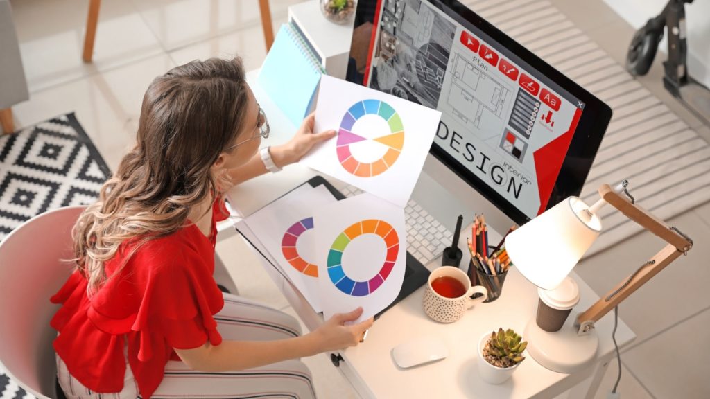 female interior designer at her computer with colour wheels in her hands