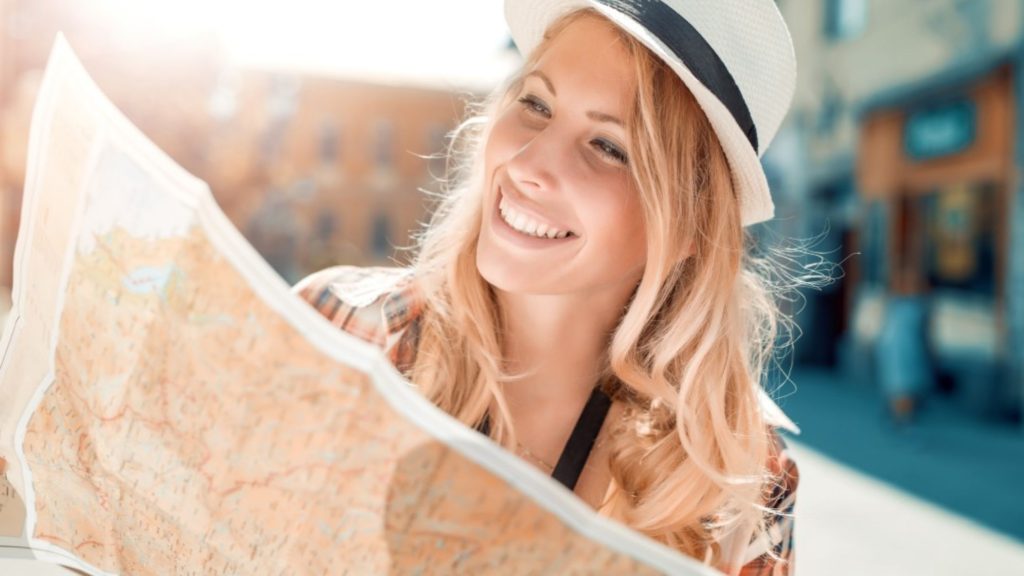 Woman holding up and reading road map