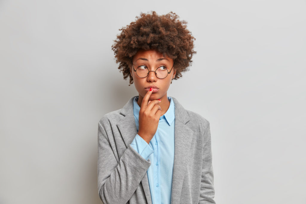 woman with serious expression touching her lips (10 Incorrect Assumptions About Introversion that Create Unfavourable Bias Towards Introverted Leaders)