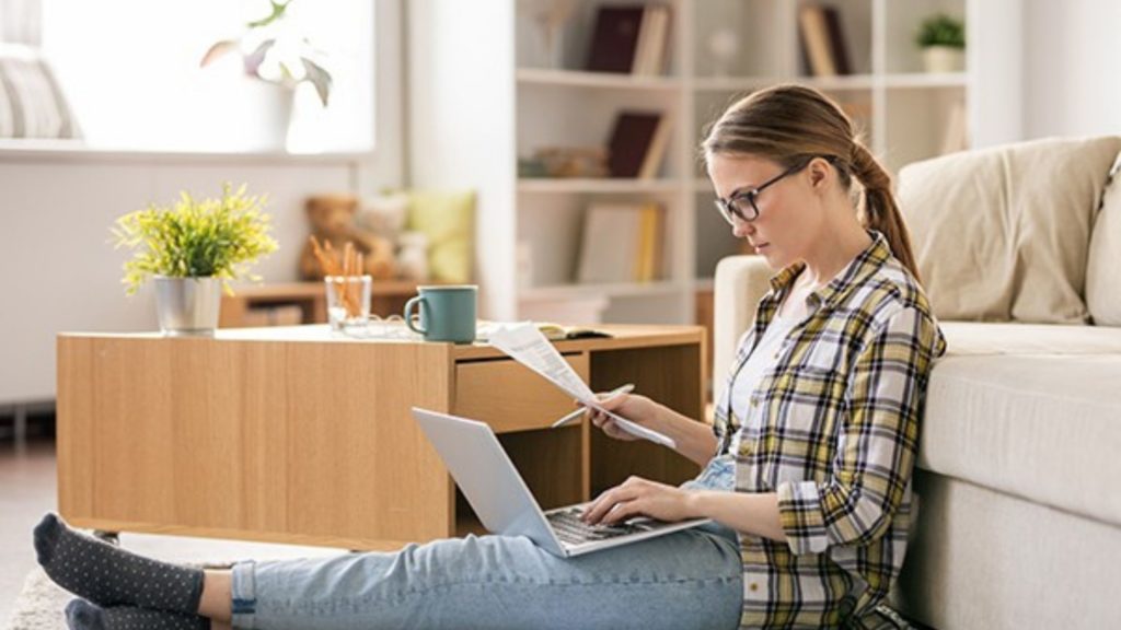 woman working from home sat with laptop on lap
