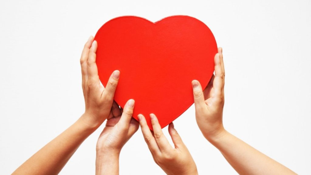 4 hands holding up a red heart - can you be too kind as a leader