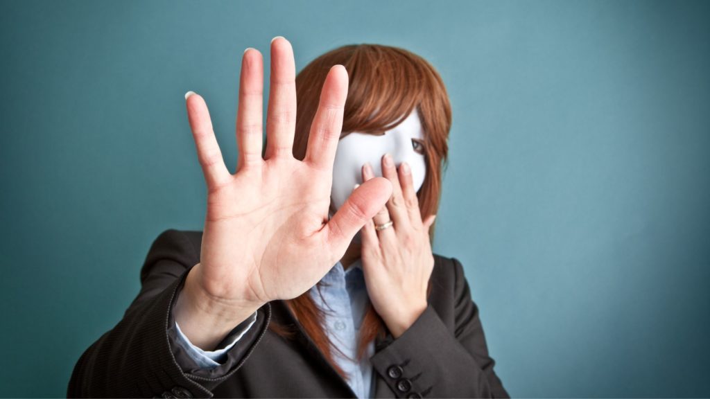 Introverted female leader hiding her identity, with mask over her face