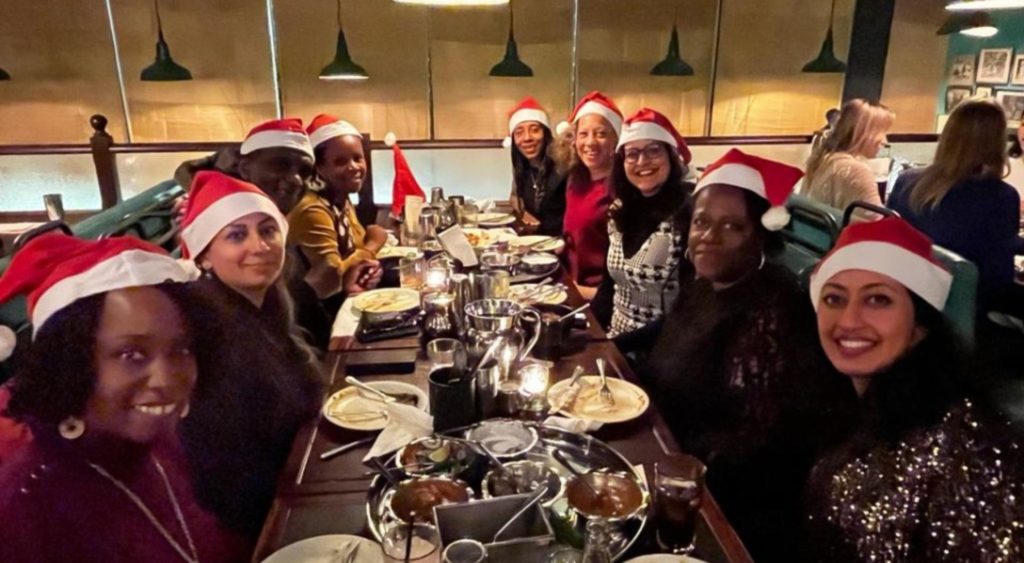 Group of senior women leaders seated around a table enjoying their Christmas meal